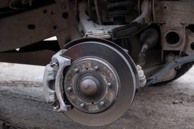 Araba tekerleği tamiri. Tekerlek çıkarıldı. Makine krikonun yanında duruyor. Fren davullarını, yayları, destekleri, süspansiyonları, tekerlek kemerini görebilirsiniz..