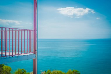 Mavi gökyüzüne karşı metal ızgara. Mavi denizin arka planında gözlem terası. Bir dağ otelinde oyun parkı. Bahar. Georgia.
