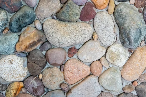 石垣を背景に 石畳で研磨された天然の石で作られた石 室内の多色天然石 — ストック写真