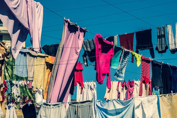 Çamaşırlar çamaşır ipinde asılı duruyor. Şehirdeki evler arasında ipler çekiliyor. Giysiler havayla kurutulmuş. Güneşli. İyi günler. Georgia.