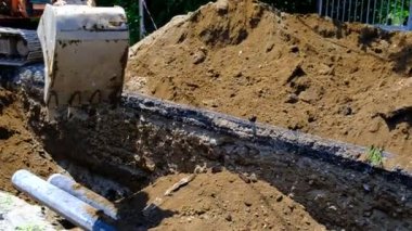 Kazıcı sipere toprak koyuyor. Toprağa borular döşeyip kum çukurlarıyla doluyor. Şehrin caddesi. İyi günler. Yaz. Georgia.