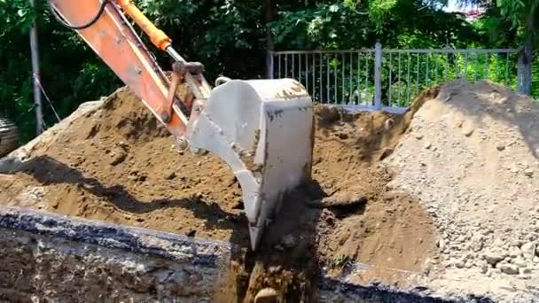 掘削機は溝に土を入れます 地面にパイプを敷設し 砂のピットで埋め戻します 街の通り ジョージア — ストック動画