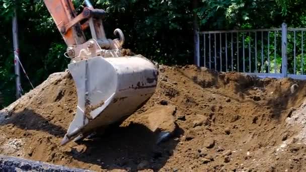 掘削機は溝に土を入れます 地面にパイプを敷設し 砂のピットで埋め戻します 街の通り ジョージア — ストック動画