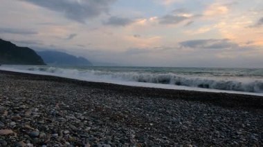 Karadeniz 'de fırtına. Dalgalar kıyıya vuruyor. Çakıl taşı plajı. Bulutlu bir yaz akşamı. Georgia.
