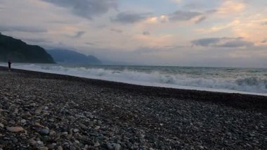 Karadeniz 'de fırtına. Dalgalar kıyıya vuruyor. Çakıl taşı plajı. Bulutlu bir yaz akşamı. Georgia.