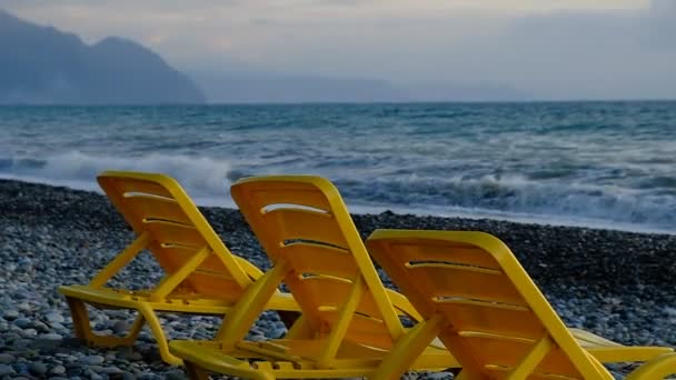 Tumbonas Plástico Amarillo Orilla Del Mar Playa Piedras Está Vacía — Vídeo de stock