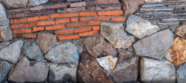 Taş ve tuğla mozaiği. Duvar doğal kaya ve çakıl taşlarından yapılmıştır. Doğal malzemelerin dokusu. Renkli bir geçmiş. Gün güneşli. Georgia.