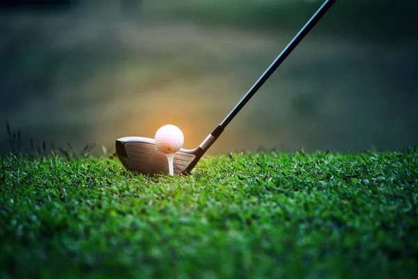 Club de golf borrosa y pelota de golf de cerca en el campo de hierba con sol —  Fotos de Stock