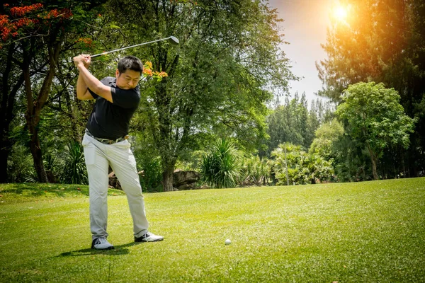在晚上的高尔夫球场上打高尔夫球的模糊的高尔夫球手，在阳光下 — 图库照片