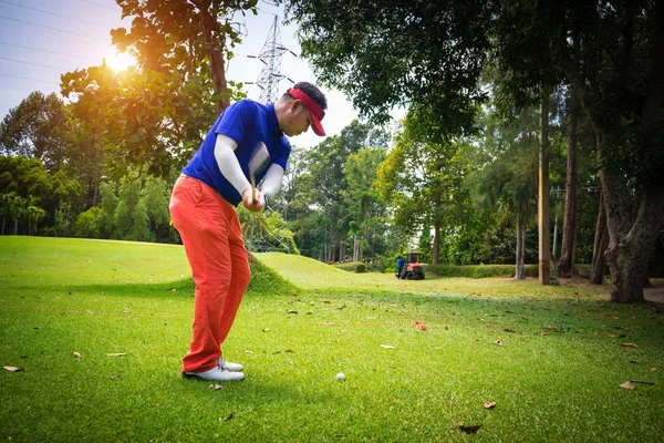 Blurred golfer playing golf on the sand in the evening golf cour