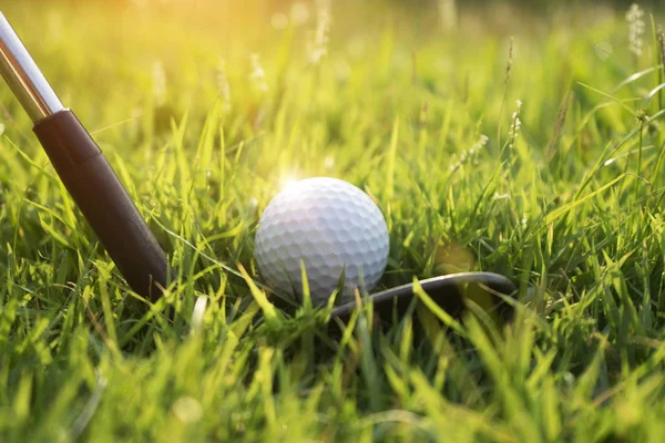 Golf pelota y club de golf en hermoso campo de golf al atardecer backg — Foto de Stock