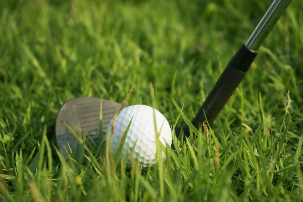 Golfbal en Golf Club in prachtige golfbaan bij zonsondergang ACHTERG — Stockfoto