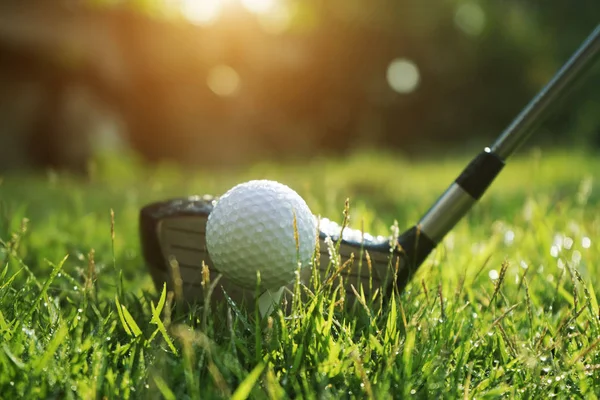 夕焼けバックグの美しいゴルフコースのゴルフボールとゴルフクラブ — ストック写真