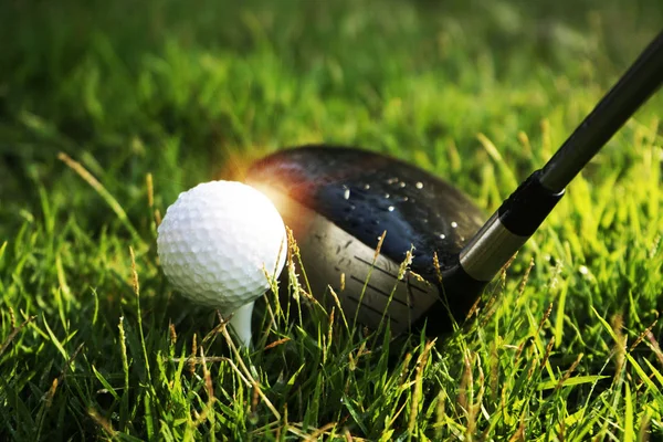Golfbal en Golf Club in prachtige golfbaan bij zonsondergang ACHTERG — Stockfoto