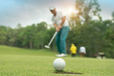 Golfçü eylem yeşil g golf topu koyarak sonra kazanmak için