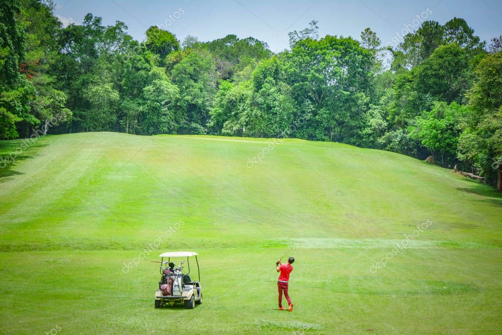 Blurred golfer playing golf in beautiful golf course in the evening golf course with sunshine in thailand
