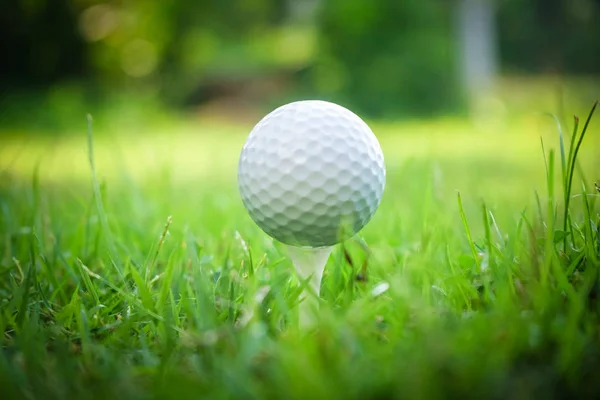 Pelota de golf en tee en hermoso campo de golf al atardecer fondo. —  Fotos de Stock