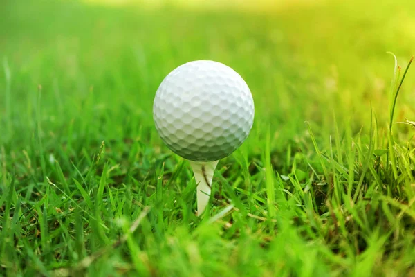 Golf piłka na tee w pięknym polu golfowym na tle zachodu słońca. — Zdjęcie stockowe