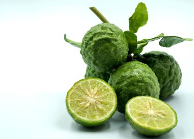 Yapraklı taze bergamot meyvesi ve beyaz arka planda yarım bergamot kesimi..                               