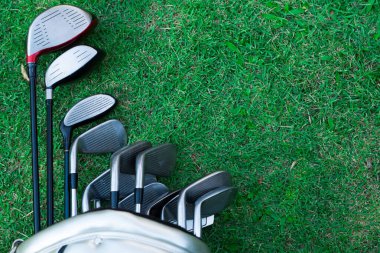 Yeşile yakın eski golf çantaları. Yeşil alan arka planında golf sopaları.. 