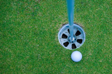 Tayland 'daki güzel golf sahasında golf ve golf sopası. Yeşil arka planda yeşil çimenler üzerinde dinlenen golf ekipmanları koleksiyonu.                                