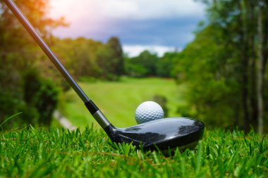 Tayland 'daki güzel golf sahasında golf ve golf sopası. Yeşil arka planda yeşil çimenler üzerinde dinlenen golf ekipmanları koleksiyonu.                                