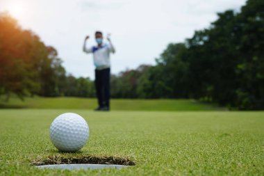 Virüs Covid 19 durumunda golf oynayan bulanık golfçü akşam golf sahasında güneşli Tayland 'da..                               