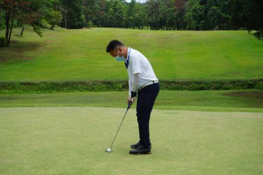 Virüs Covid 19 durumunda golf oynayan bulanık golfçü akşam golf sahasında güneşli Tayland 'da..                               