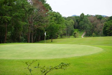 Akşam golf sahasının arka planında Tayland 'daki golf sahasında güneş ışığı var. Bir yaz öğleden sonra golf sahasında güzel bir manzara..                                