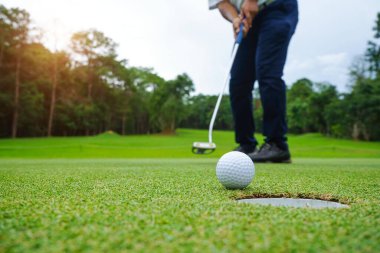 Bulanık golfçü akşam vakti golf sahasında golf oynuyor. Güneşin altında golf oynayan bir adam..                                