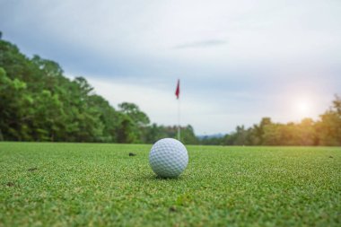 Tayland 'da güneş ışığıyla akşam golf sahasında bulanık golf topu..                                