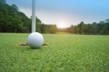 Tayland 'da güneş ışığıyla akşam golf sahasında bulanık golf topu..                                
