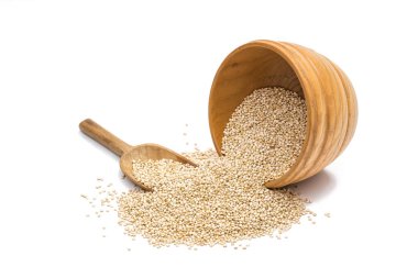 Quinoa tohumları bir yuvarlak devrilmiş ahşap kase ve bir kaşık dışarı dökülen beyaz arka plan üzerinde izole