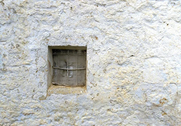 Eşit derecede rustik İspanyol bir şekilde beyaz bir duvarda rustik pencere.