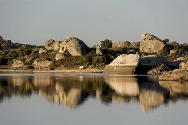 Açıkça yansıtıldığı bir lagün üzerindeki kayaların arka planı.