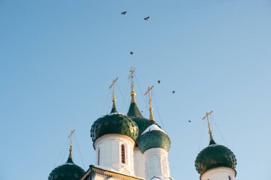 Mavi bir gökyüzüne karşı beyaz taş tapınağın üzerinde haçlar ile birkaç kubbe