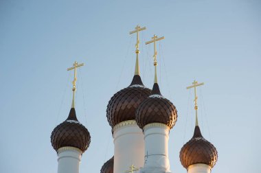 Mavi bir gökyüzüne karşı beyaz taş tapınağın üzerinde haçlar ile birkaç kubbe