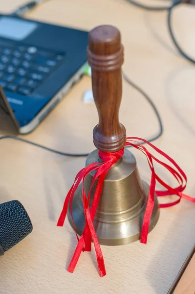 The school bell on the table with red ribbons