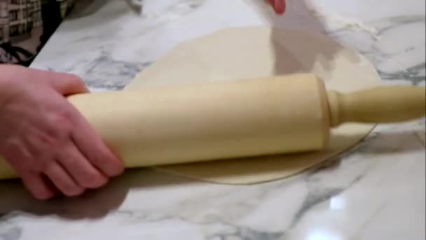 Childrens handen roll out pizzadeeg deegroller op de tafel — Stockvideo