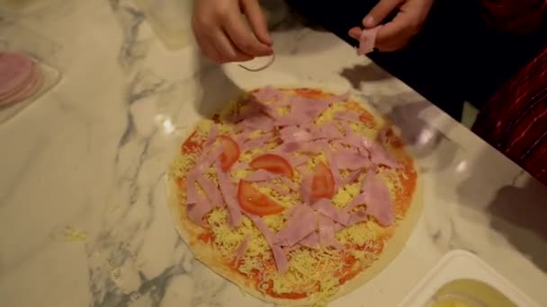 Manos de los niños hacen pizza, añadir jamón en el pastel — Vídeos de Stock