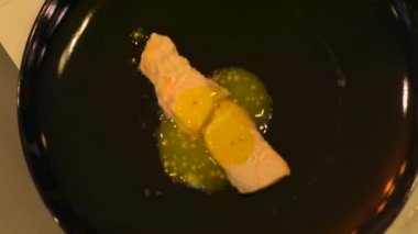 Lezzetli pişmiş somon tabağına sos döken kadın..