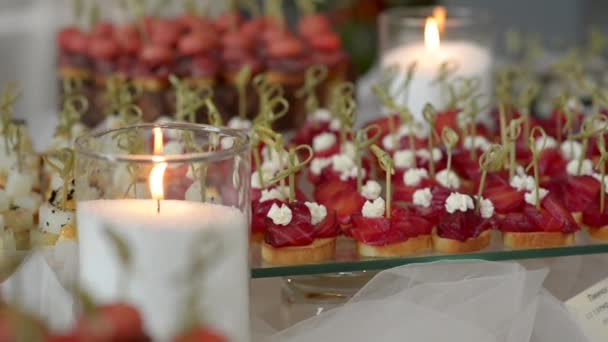 Pinchos mit Roter Bete auf einem Glasständer mit brennenden Kerzen — Stockvideo
