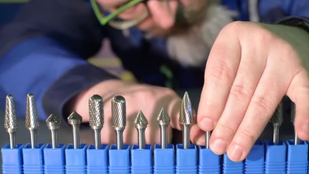 A man arranges small cutters. — Stock Video