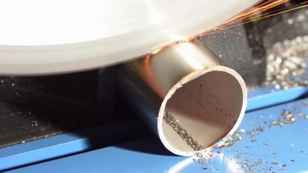 Trabalhando com uma serra circular para serrar um pedaço de tubo de aço inoxidável — Vídeo de Stock