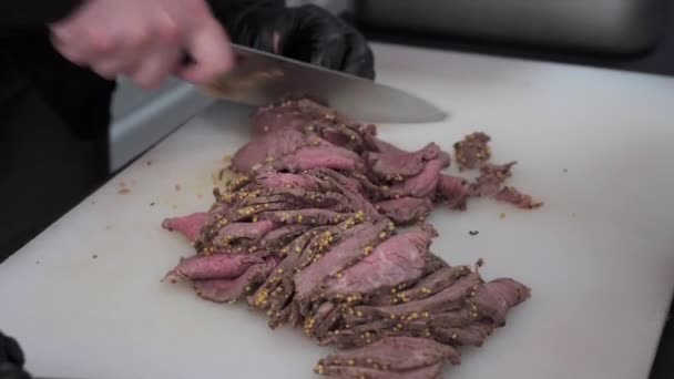 Повар режет пряное мясо тонкими ломтиками — стоковое видео