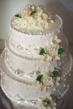 krem güller ve yeşil tilkiyle üç katmanlı düğün pastası