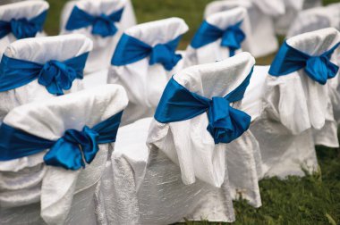 Düğün büfesinde mavi kurdelelerle dekore edilmiş sandalyeler