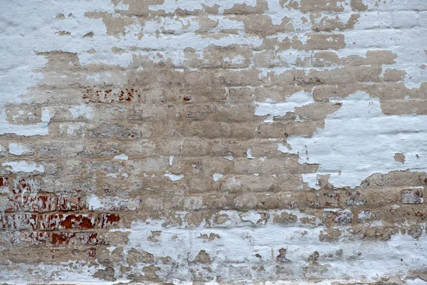 old dilapidated brick wall, crumbling plaster