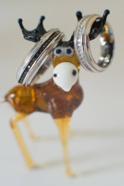 Bir oyuncak geyiğin boynuzlarında asılı alyanslar, yakın çekim