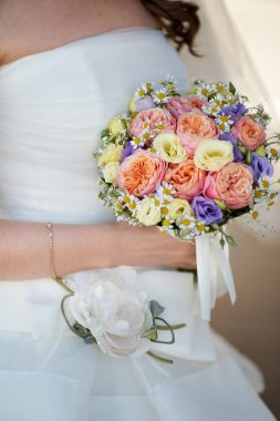 Gelin sarı tonlarda düğün buketi tutar